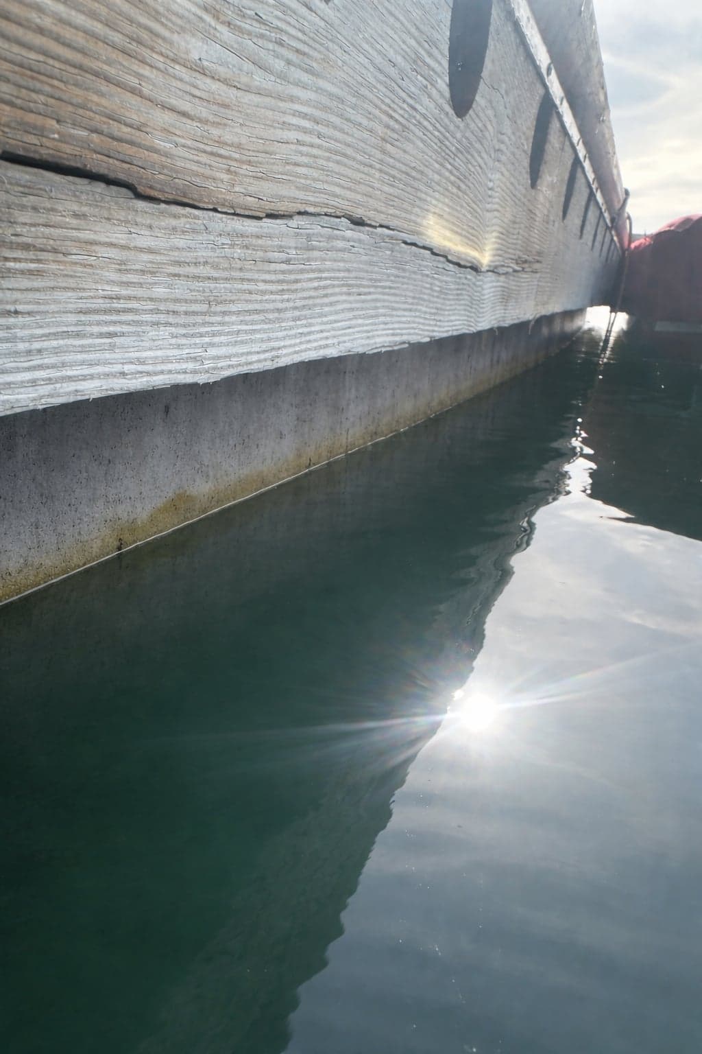 Concrete dock face with horizontal cracking along the top edge
