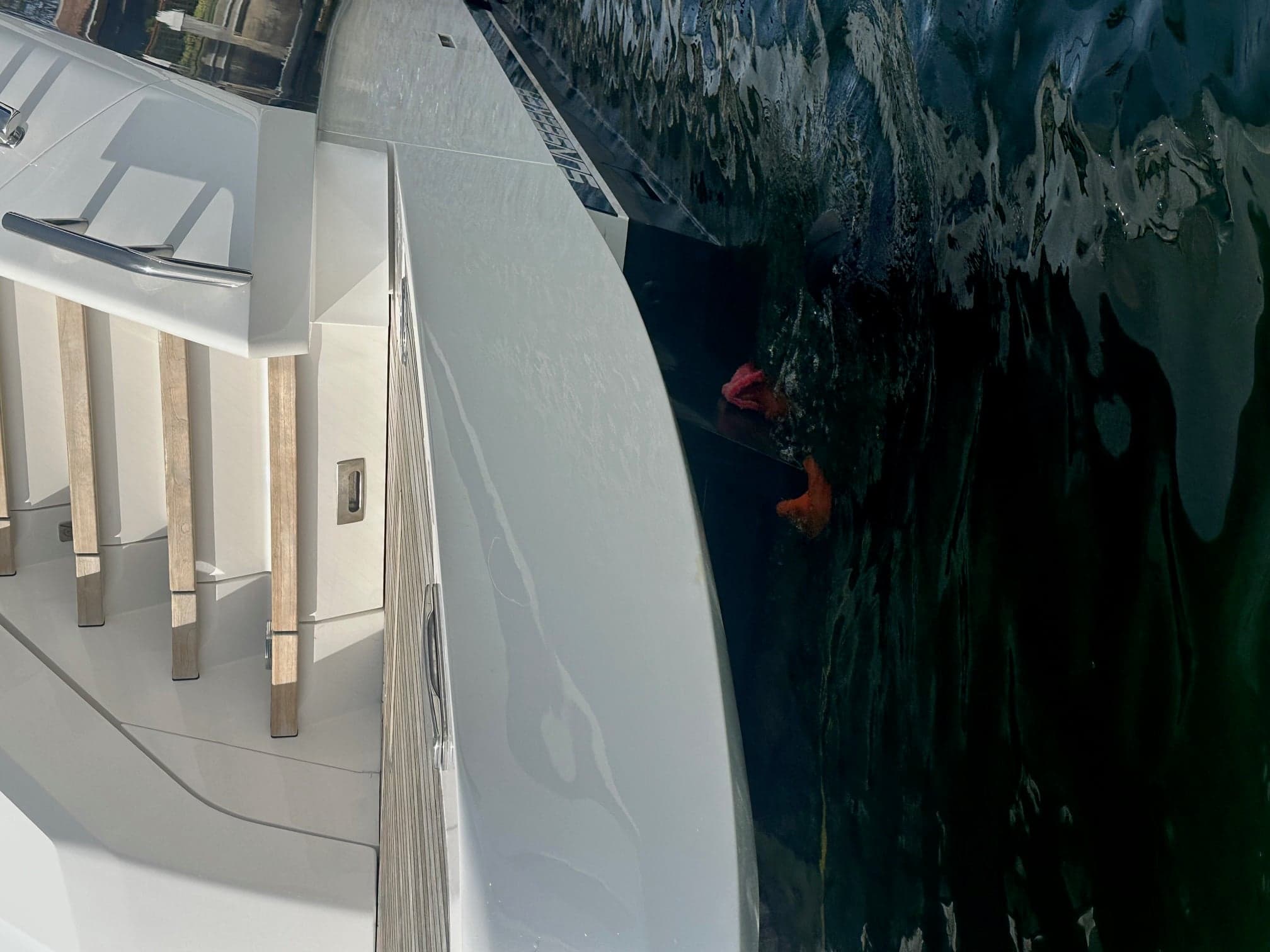 Diver slightly underwater cleaning the bottom of a vessel