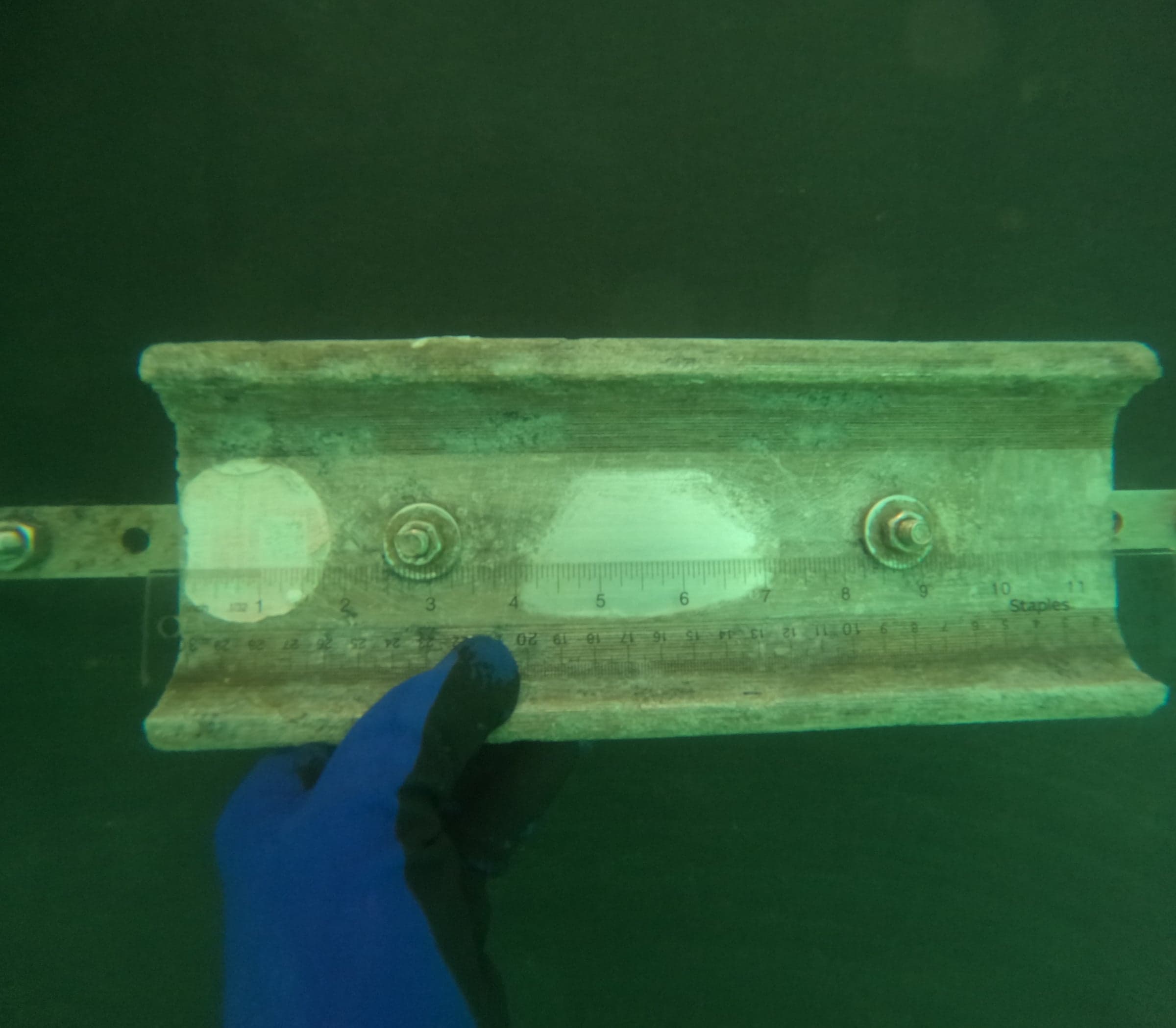 Hull-mounted anode mid-life with ruler held against it, partial wear visible