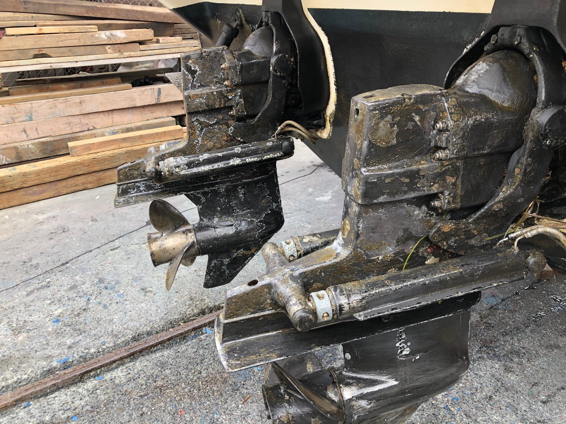 Twin sterndrive units side by side both showing widespread corrosion